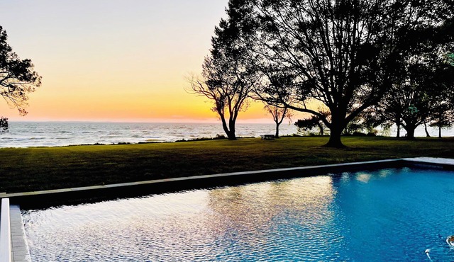 A stunning Chesapeake Bay sunset from a beautiful home with an inground pool! in Rock Hall