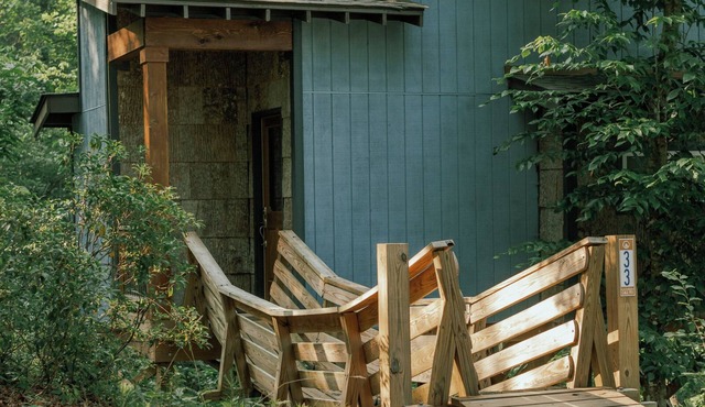 Romantic treehouse nestled on the creek, private deck, loft bedroom, shower skylights, bridge, sleeps 3. in Mill Spring
